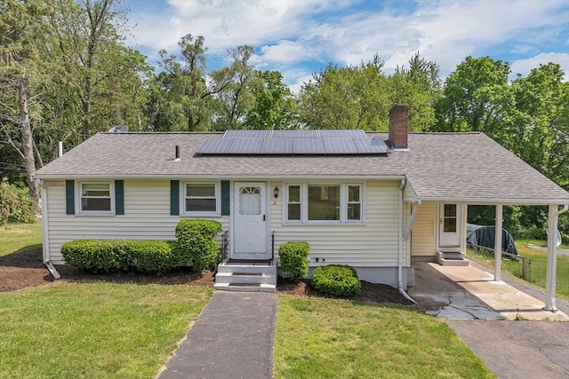 21 Gile St, Haverhill, MA 01830 - view of front of property with a front lawn, a chimney, a carport, and roof mounted solar panels