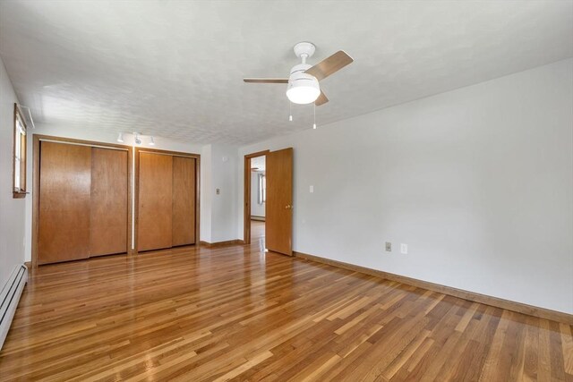 21 Gile St, Haverhill, MA 01830 - unfurnished bedroom featuring two closets, light wood finished floors, baseboards, and baseboard heating