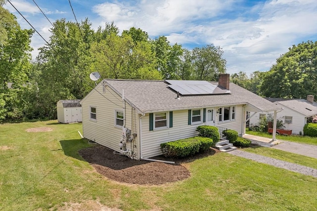 21 Gile St, Haverhill, MA 01830 - view of front of property with a chimney, roof mounted solar panels, a front lawn, and a shingled roof