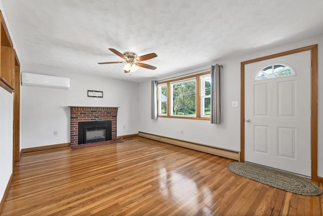 21 Gile St, Haverhill, MA 01830 - entrance foyer featuring a wall mounted AC, baseboard heating, light wood-style floors, plenty of natural light, and a textured ceiling