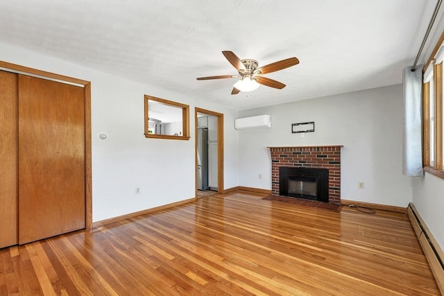 21 Gile St, Haverhill, MA 01830 - unfurnished living room with a wall mounted AC, a baseboard radiator, a ceiling fan, light wood-type flooring, and a fireplace