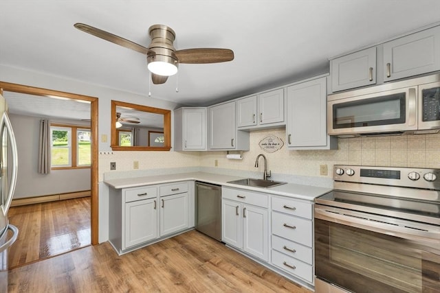 21 Gile St, Haverhill, MA 01830 - kitchen featuring stainless steel appliances, a sink, a ceiling fan, a baseboard radiator, and tasteful backsplash