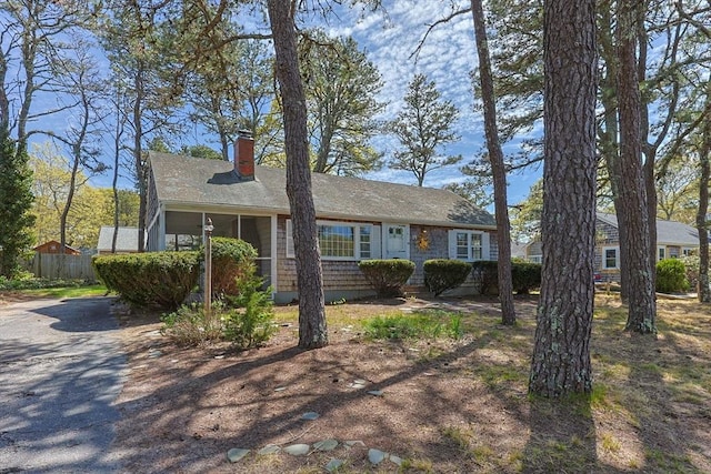 view of front of home featuring a chimney, fence, and driveway
