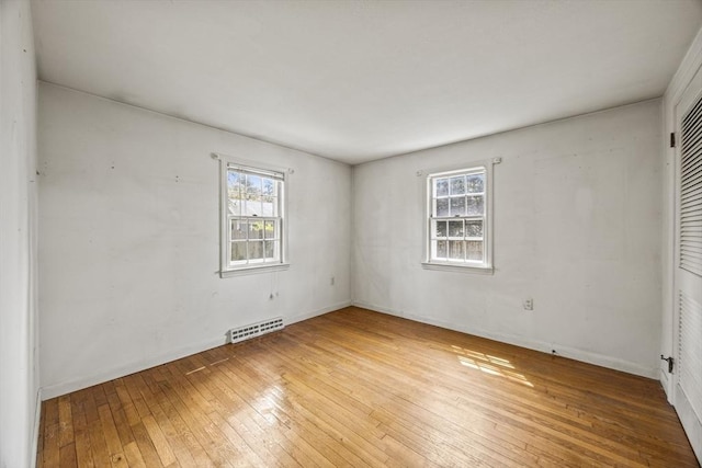 spare room with healthy amount of natural light, hardwood / wood-style flooring, and baseboards