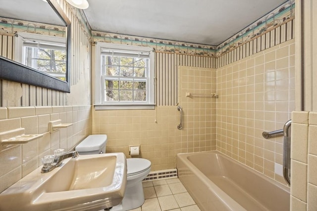 bathroom featuring toilet, tile patterned floors, wallpapered walls, healthy amount of natural light, and a sink