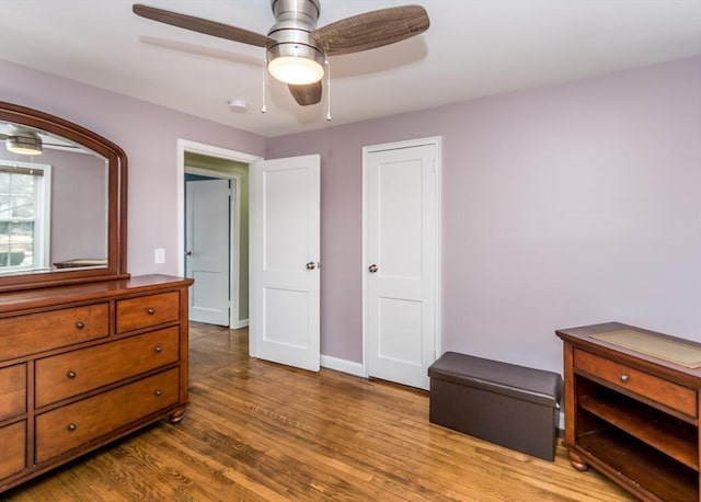 bedroom featuring a ceiling fan, wood finished floors, and baseboards