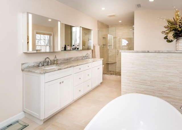 bathroom featuring a sink, a freestanding bath, a stall shower, and double vanity