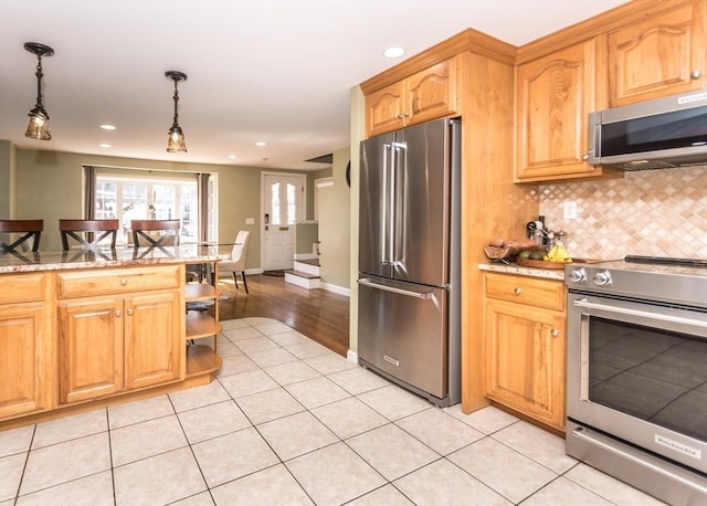 kitchen with light stone counters, decorative backsplash, light tile patterned floors, appliances with stainless steel finishes, and hanging light fixtures