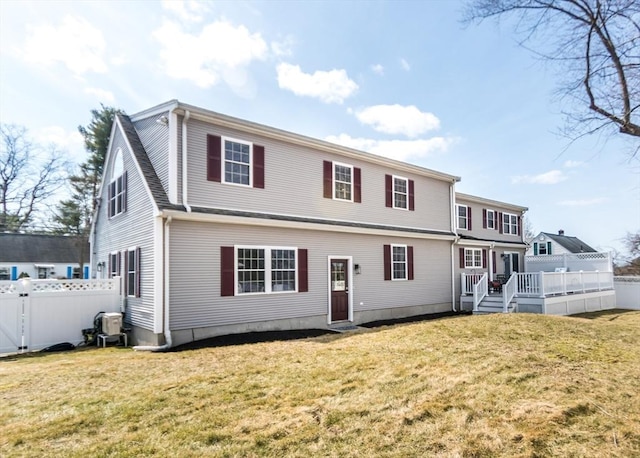 view of front of house with a wooden deck, a front lawn, and fence