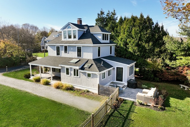 back of house with outdoor lounge area, a yard, and a patio