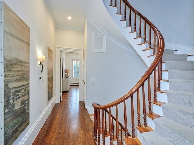 stairs with hardwood / wood-style floors and ornamental molding