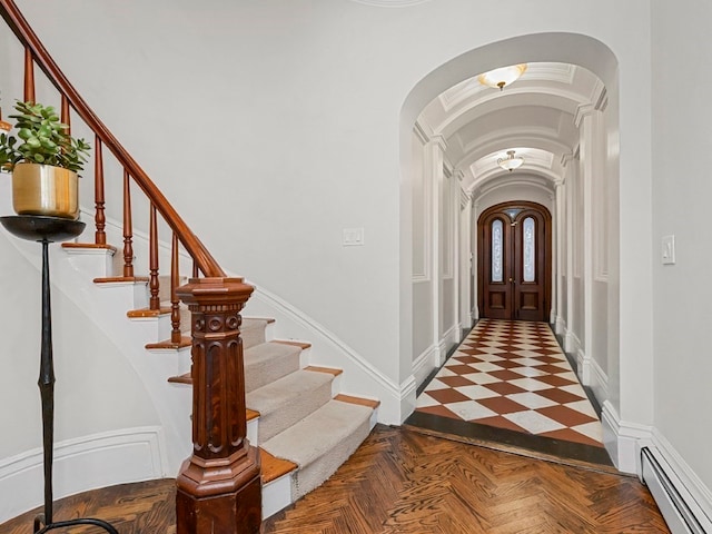 foyer featuring parquet flooring and a baseboard heating unit