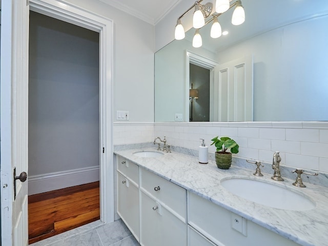 bathroom with tile patterned floors, vanity, ornamental molding, and tasteful backsplash