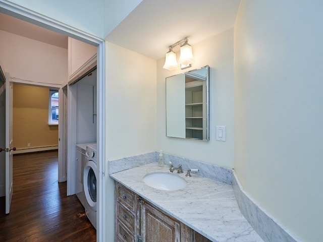 bathroom featuring separate washer and dryer, vanity, wood-type flooring, and a baseboard heating unit