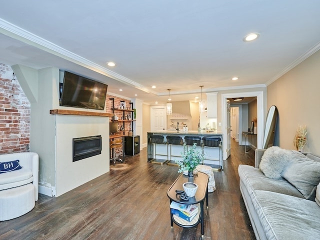 living room featuring crown molding, brick wall, and dark hardwood / wood-style floors