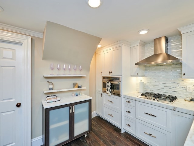 kitchen with dark hardwood / wood-style floors, white cabinetry, wall chimney range hood, and stainless steel appliances