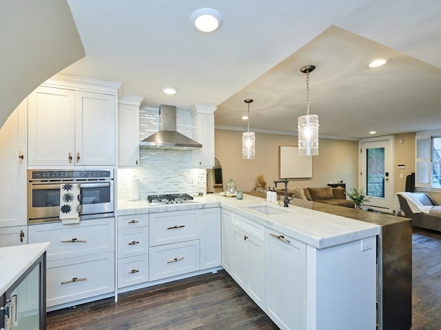 kitchen featuring dark wood-type flooring, sink, wall chimney exhaust hood, white cabinetry, and stainless steel appliances