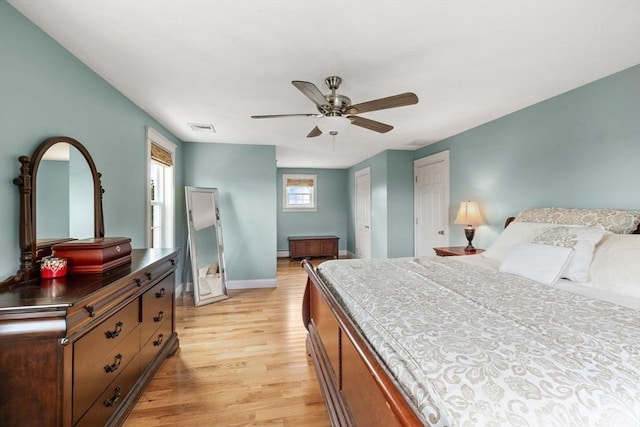 bedroom featuring visible vents, ceiling fan, baseboards, and light wood-style floors