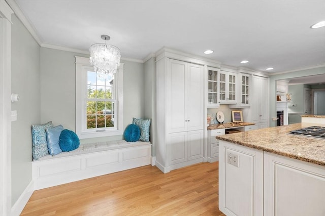 kitchen featuring crown molding, white cabinets, and light wood-style floors