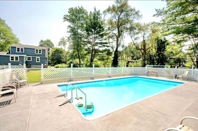 pool with a patio and fence