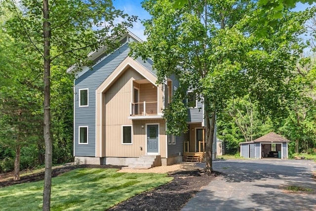 174 Gilbert St, Mansfield, MA 02048 - view of front of house featuring a balcony, an outdoor structure, and a front yard