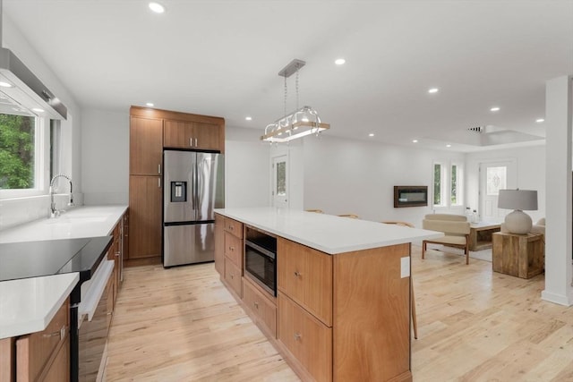 174 Gilbert St, Mansfield, MA 02048 - kitchen featuring stainless steel refrigerator with ice dispenser, built in microwave, wall chimney range hood, healthy amount of natural light, and recessed lighting