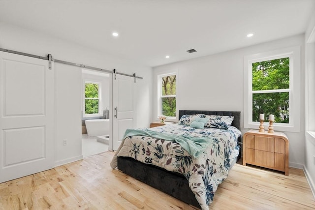 174 Gilbert St, Mansfield, MA 02048 - bedroom with a barn door, multiple windows, wood finished floors, and recessed lighting