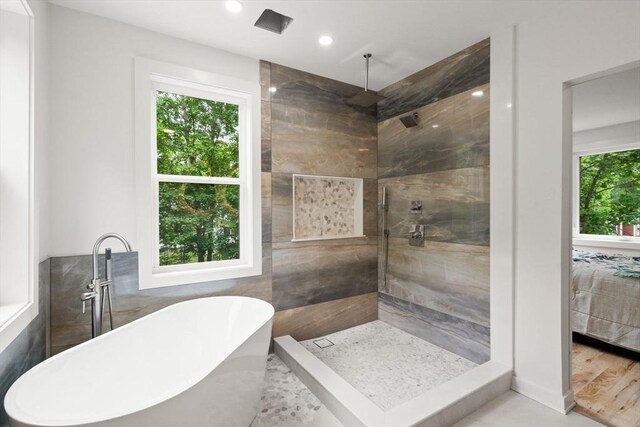 174 Gilbert St, Mansfield, MA 02048 - ensuite bathroom featuring healthy amount of natural light, a freestanding bath, a tile shower, recessed lighting, and tile walls