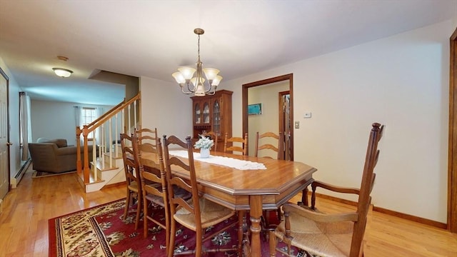 dining space with light hardwood / wood-style flooring and a notable chandelier