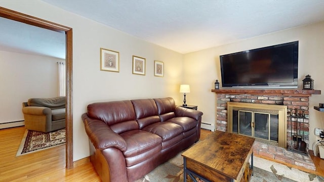 living room featuring hardwood / wood-style flooring, a baseboard heating unit, and a fireplace