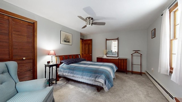 carpeted bedroom featuring ceiling fan, a baseboard radiator, multiple windows, and a closet