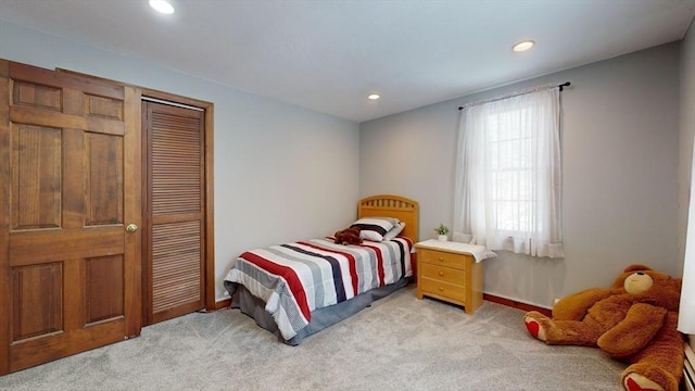 bedroom with light colored carpet and a closet