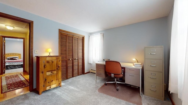 carpeted home office with a baseboard radiator