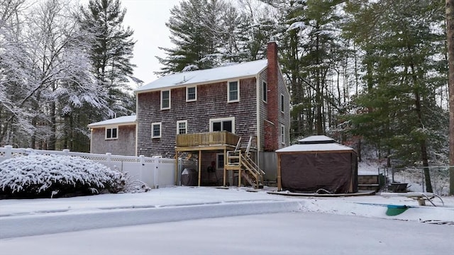 snow covered house with a gazebo and a deck