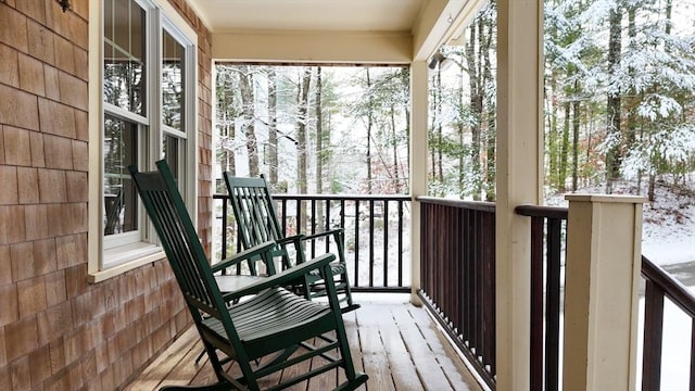 view of snow covered back of property