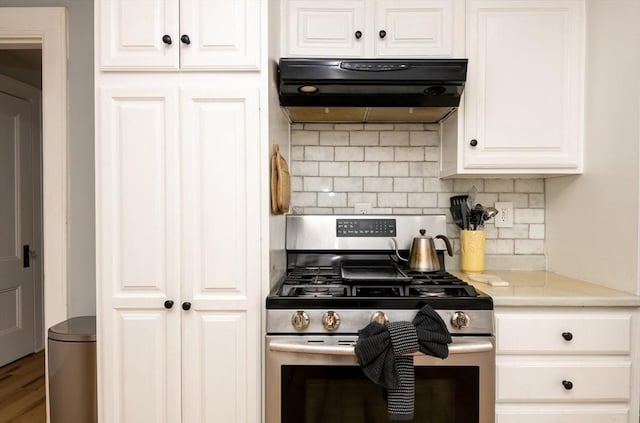 35 Locust St Unit 3, Danvers, MA 01923 - kitchen featuring stainless steel gas range, exhaust hood, backsplash, white cabinetry, and light countertops