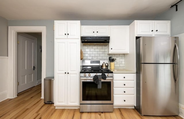 35 Locust St Unit 3, Danvers, MA 01923 - kitchen featuring appliances with stainless steel finishes, under cabinet range hood, light wood-style flooring, and white cabinetry