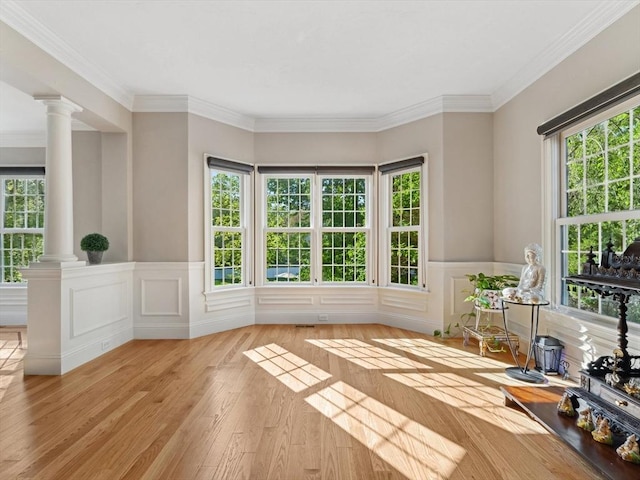 231 Gulf St, Shrewsbury, MA 01545 - unfurnished living room with ornate columns, healthy amount of natural light, wood finished floors, wainscoting, and crown molding