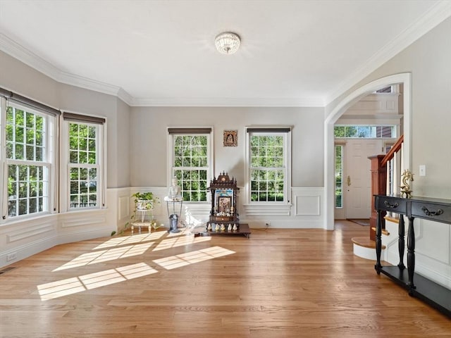 231 Gulf St, Shrewsbury, MA 01545 - living area featuring plenty of natural light, wood finished floors, arched walkways, crown molding, and a wainscoted wall