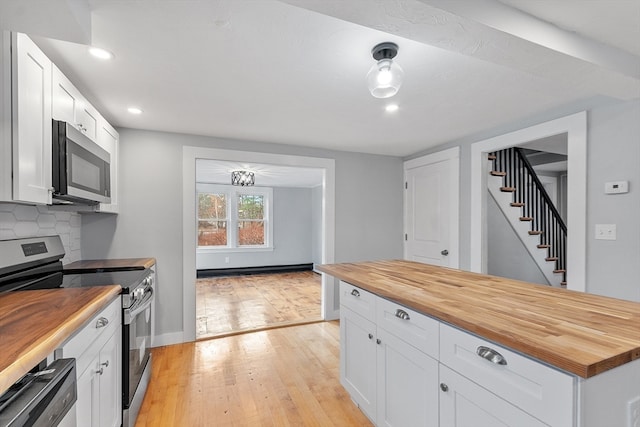 kitchen with wood counters, decorative backsplash, stainless steel appliances, light hardwood / wood-style flooring, and white cabinets