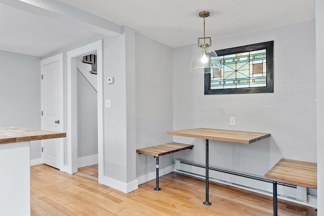 dining space featuring a baseboard heating unit and light hardwood / wood-style floors