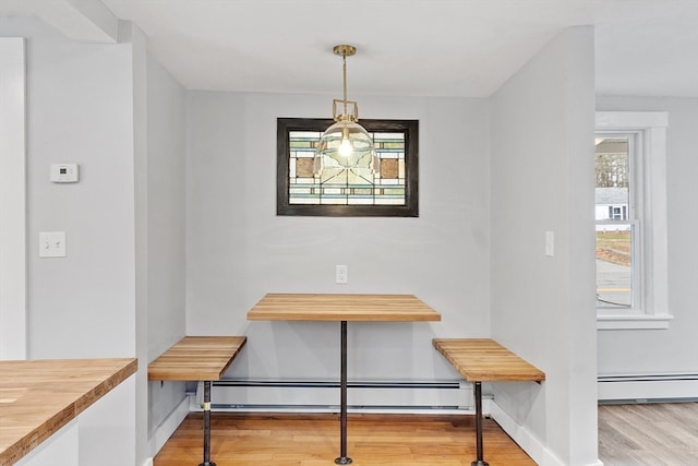 dining space with wood-type flooring and a baseboard radiator