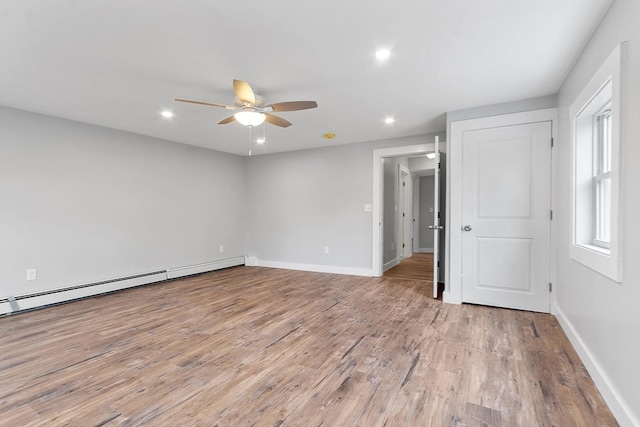 unfurnished bedroom featuring baseboard heating, ceiling fan, and light wood-type flooring