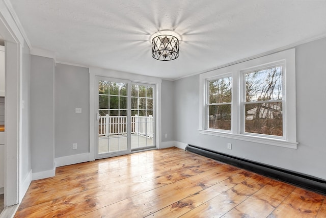 interior space featuring a chandelier, a baseboard radiator, light hardwood / wood-style flooring, and a healthy amount of sunlight