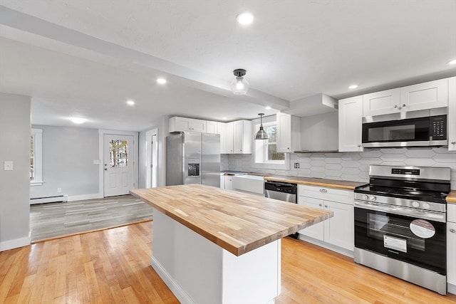 kitchen featuring pendant lighting, white cabinetry, stainless steel appliances, and wooden counters