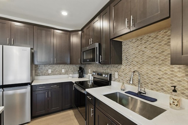 kitchen featuring a sink, decorative backsplash, appliances with stainless steel finishes, and dark brown cabinets
