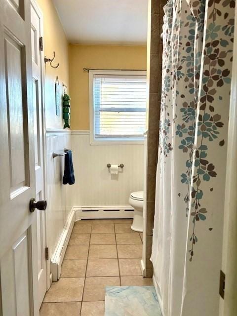 bathroom featuring baseboard heating, toilet, a shower with curtain, and tile patterned flooring