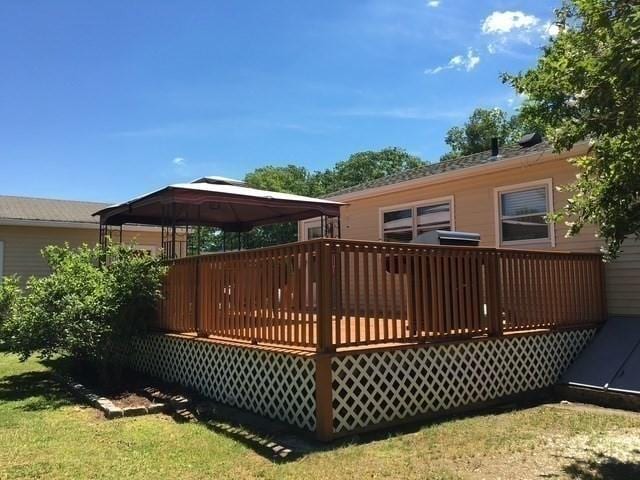 rear view of house featuring a wooden deck and a gazebo