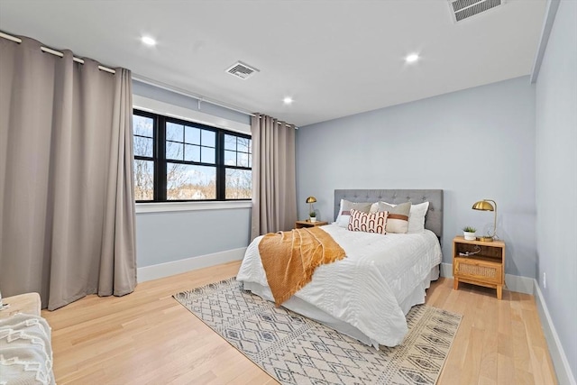 bedroom with light wood-style floors, baseboards, and visible vents