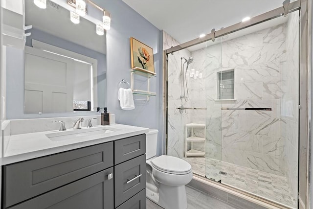 full bath with vanity, a marble finish shower, and toilet